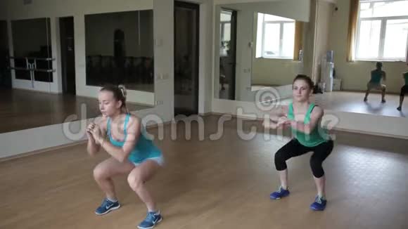 两个女孩蹲在健身房视频的预览图