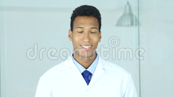 积极的微笑让坐在诊所的美国黑人医生放松外科医生视频的预览图