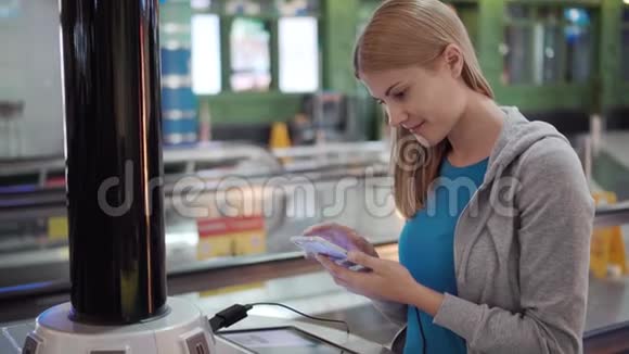 机场航站楼里漂亮迷人的女人站在智能手机充电插头附近视频的预览图