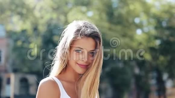 美丽的年轻女子的肖像蓝色的眼睛和迷人的微笑她站在一条街的中间视频的预览图