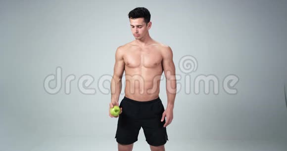 一位男性健身模特对苹果说是快乐健康的生活白色背景4k慢动作视频的预览图