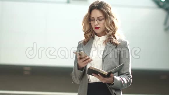 商务女性从智能手机上发送信息穿西装的女孩接电话年轻人的肖像视频的预览图