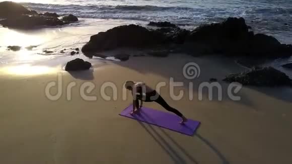 女孩站在瑜伽位置海滩上景视频的预览图