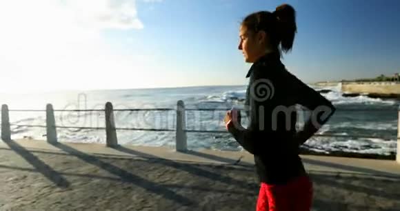 女性慢跑者在海边慢跑4K视频的预览图