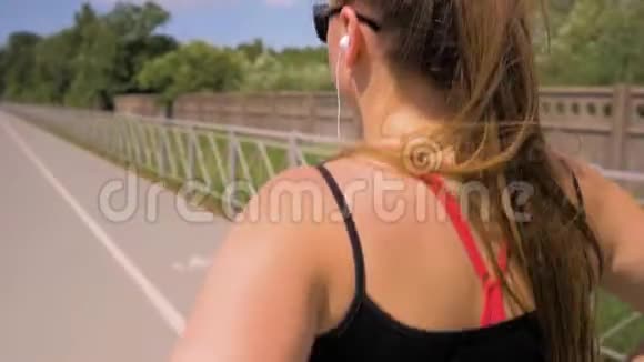 戴眼镜和耳机的运动女孩到处跑中弹视频的预览图