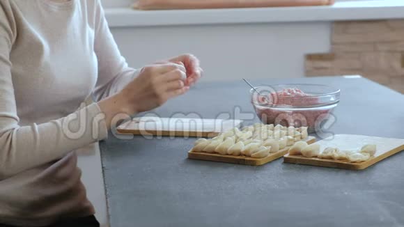 女人用肉馅包饺子特写手侧视视频的预览图