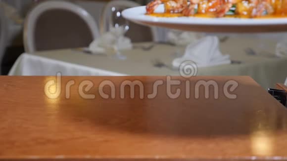 在餐馆里服务员戴着手套端上了一盘虎虾这是佛兰贝风格的菜肴慢烟视频的预览图