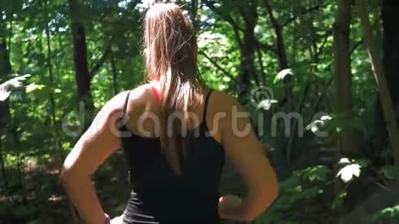 穿紧身裤的运动女孩训练后离开公园中弹慢动作视频的预览图