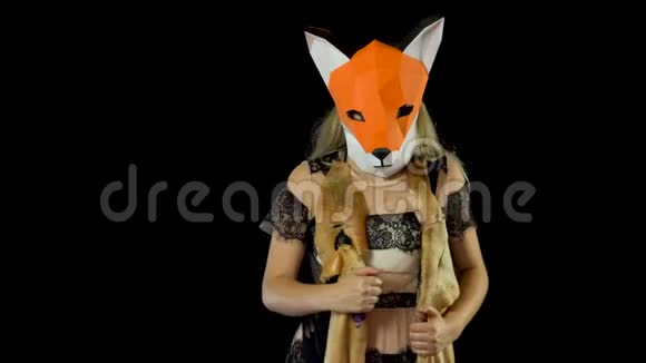 金发女孩用狐狸面膜纸用猪皮覆盖黑色背景4kUHD视频的预览图