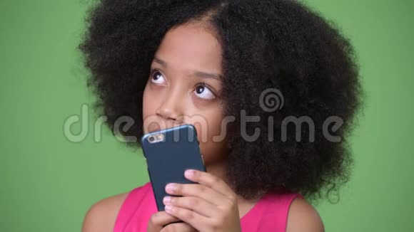 年轻可爱的非洲女孩有非洲头发用电话思考视频的预览图