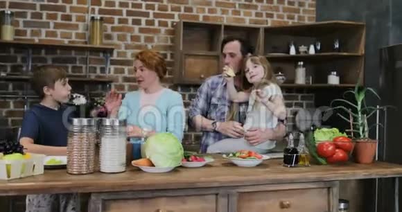 欢乐的家庭在厨房里给高五个厨师一起做饭在家快乐的微笑父母有两个孩子视频的预览图