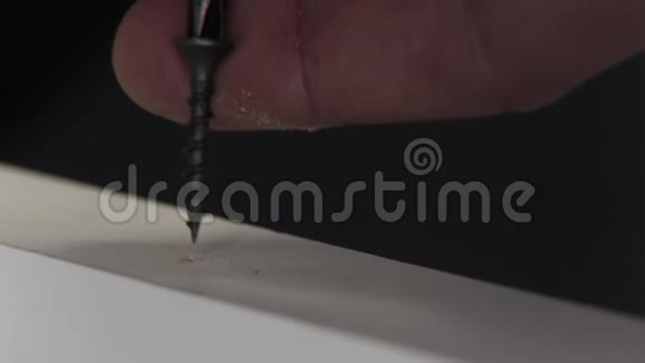 DIY家居木制家具司机宏观的特写镜头一个人用螺丝刀把一个黑色的东西拧进视频的预览图