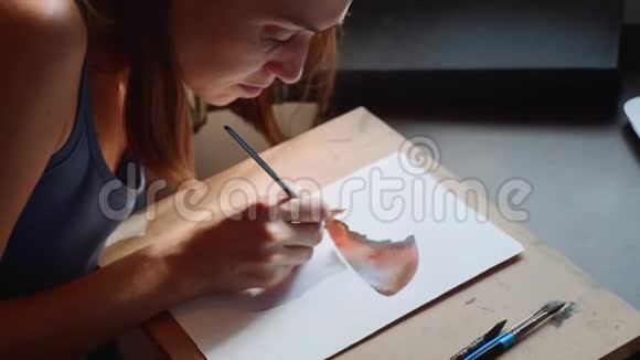 年轻女子在家中通过网上水彩画课视频的预览图