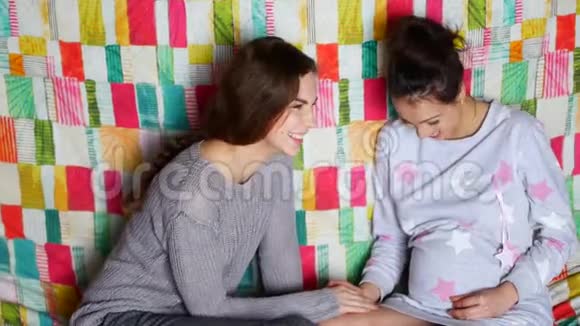 这个女孩正在拜访一个怀孕的朋友美丽的年轻女人谈笑风生视频的预览图