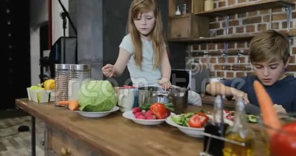 快乐的家庭在厨房准备食物父母看着孩子切食材做晚餐视频的预览图