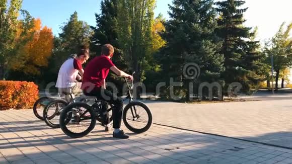 在夏天阳光明媚的公园里极端的bmx骑自行车和跳跃酷小的宝马自行车使奥利魔术视频的预览图