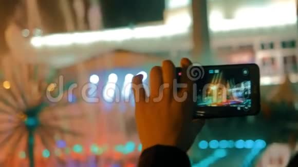晚上在城市喷泉的智能手机上录制视频的预览图