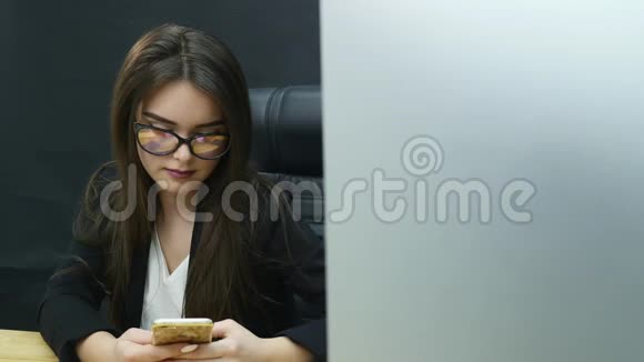 女商人在办公室里使用手机视频的预览图