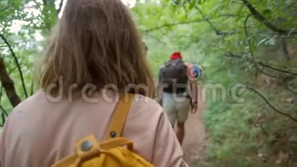 一群徒步旅行者在丛林中旅行年轻的Hispters带着背包走过密集的旅行车后景视频的预览图