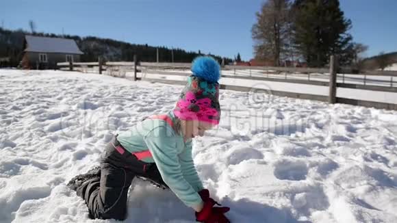 穿暖衣服的漂亮女孩是在温暖的阳光日在外面玩雪冬季及儿童概念视频的预览图
