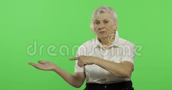 一位老妇人指着某物微笑老奶奶铬键视频的预览图
