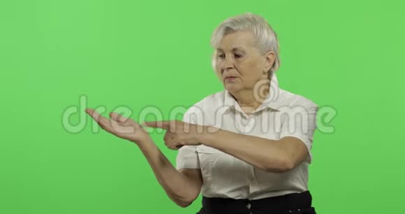 一位老妇人指着某物微笑老奶奶铬键视频的预览图