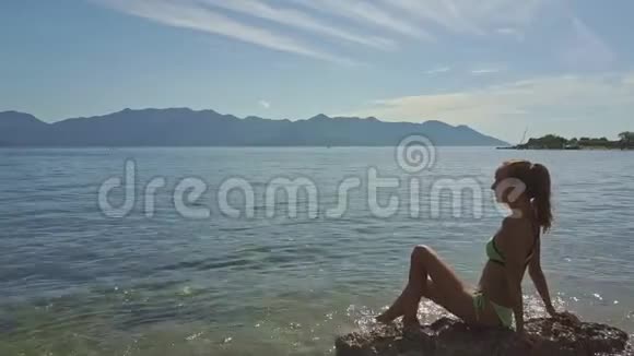 浅海浅海石头上的钻孔侧视女孩视频的预览图
