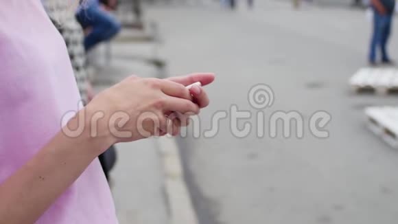 女孩把手指指向城市背景上的智能手机屏幕人们嬉皮士用手机视频的预览图