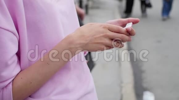 女孩把手指指向城市背景上的智能手机屏幕人们嬉皮士用手机视频的预览图