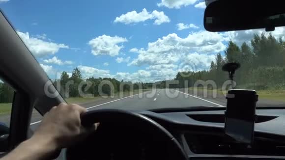 人在高速驾驶汽车用手握着车轮路蓝天视频的预览图