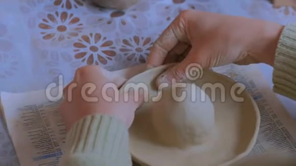 女陶工在制陶车间制作粘土柠檬榨汁机视频的预览图