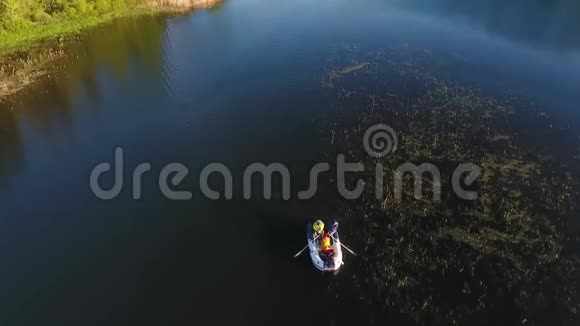 年轻的朋友乘船划过美丽的湖高空高清视频的预览图