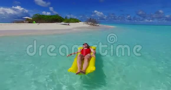 马尔代夫白色沙滩2男青年夫妇在充气床垫上漂浮游泳视频的预览图