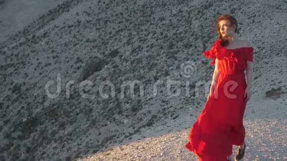 穿红袍的年轻女子望着太阳吹风视频的预览图