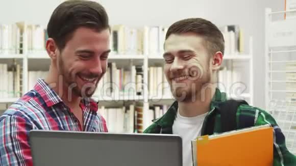 两个年轻的学生站在图书馆笑视频的预览图