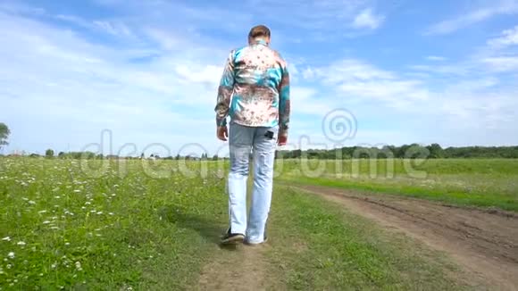 一个英俊的男人独自在田野里散步视频的预览图