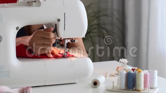 女裁缝在车间缝纫机上手工缝制红布视频的预览图