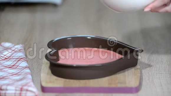 将香草慕斯倒入心形模具在厨房做摩丝蛋糕的甜点视频的预览图