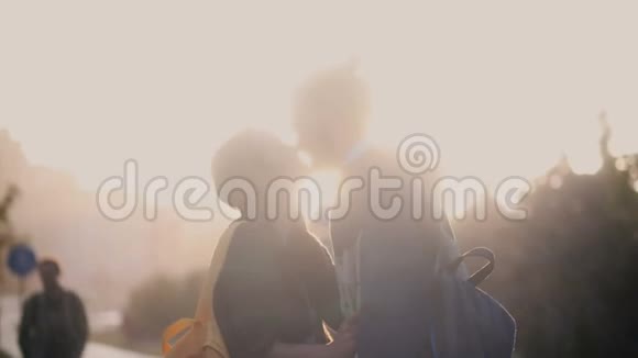 年轻幸福的夫妇冒雨在市中心散步美丽的男女在夕阳下亲吻拥抱视频的预览图