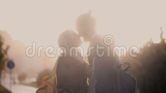 浪漫的约会年轻漂亮的夫妇在雨中幸福的男人和女人在夕阳下走在外面视频的预览图