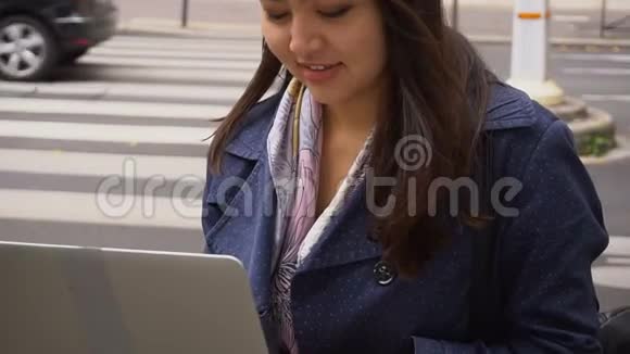 中国学生在外面用笔记本电脑打字有道路背景视频的预览图