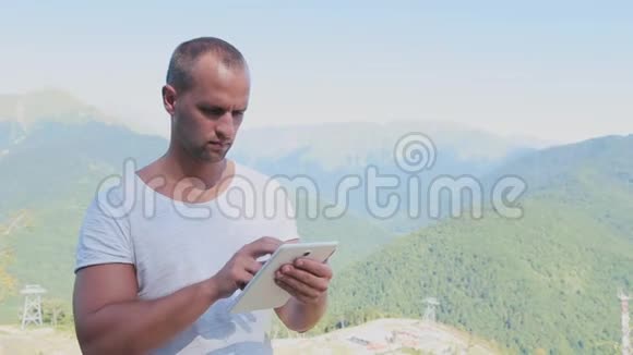 人手触摸山背景上数字平板的屏幕视频的预览图