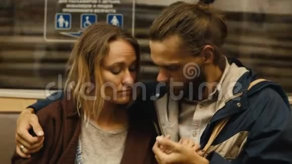 年轻漂亮的一对夫妇牵着手在地铁车里说话火车站和时髦的男人和女人离开地铁视频的预览图