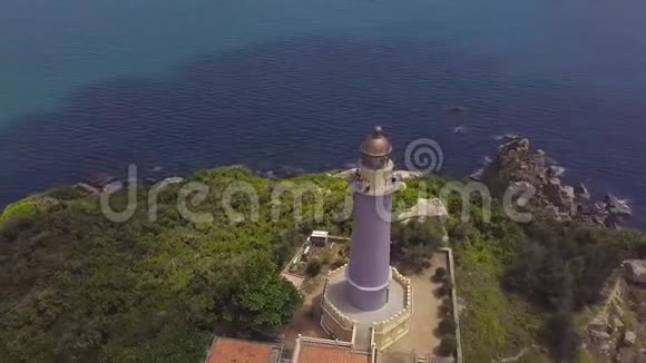 海上灯塔上山崖和帆船无人机观景青山上的空中景观海光房子视频的预览图