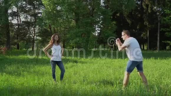 帅哥在公园用相机拍年轻快乐孕妇的照片视频的预览图