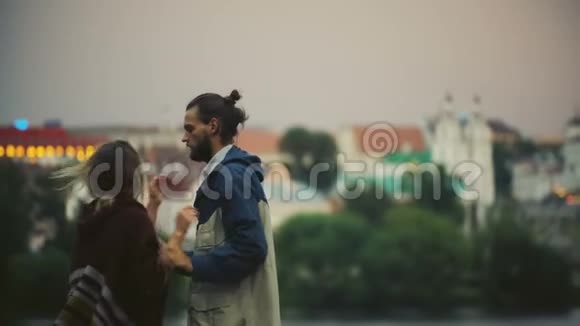 年轻的幸福夫妇在日落时分在市中心散步时尚的男人和女人拥抱亲吻一起玩视频的预览图