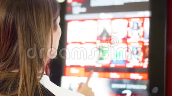 青少年从电影院的自动售货机买电影票女性通过触摸屏幕做手势视频的预览图