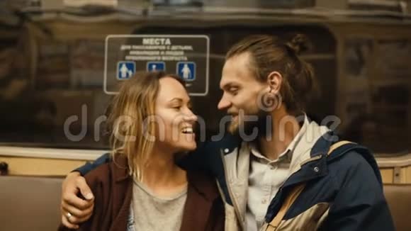 年轻漂亮的夫妇一起乘地铁回家快乐的男人和女人说话坐在一堆视频的预览图