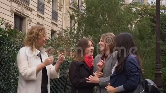 快乐的女学生在大学大楼附近慢动作地在外面说话视频的预览图
