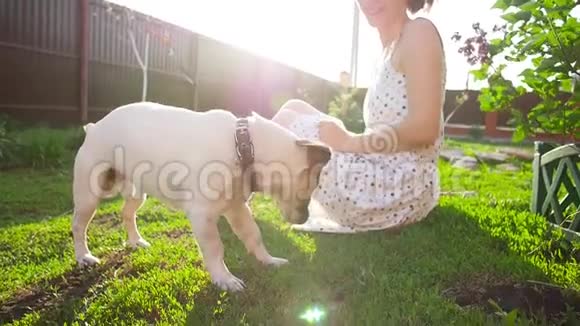 友谊和宠物的概念快乐的年轻女人和狗在草地上玩视频的预览图